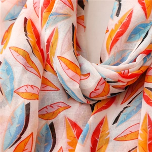 Gros plan du châle léger montrant des motifs de plumes et la texture du tissu fin