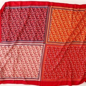 Flat lay of square shawl with multi-color floral print panels and red borders