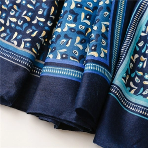 Detailed macro view of dark blue scarf fabric with gold patterns and fine twill texture
