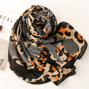 Detail of leopard print scarf with mesh grid patterns in black, orange, and beige