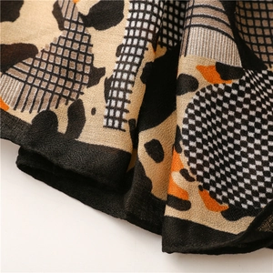Macro detail of cotton linen scarf with leopard print texture and orange color blocks