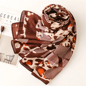 Detail of soft leopard pattern scarf with light material texture and magazines