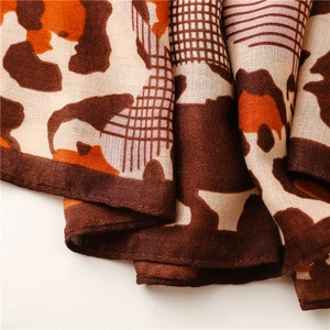Detailed close-up of leopard print scarf with soft texture and refined stitched edges