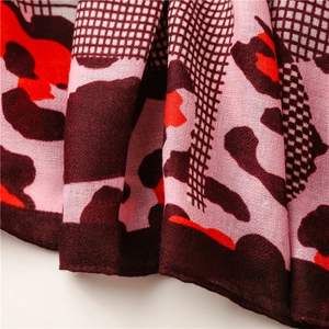 Detail of red leopard print and coffee check pattern on lightweight woven scarf fabric
