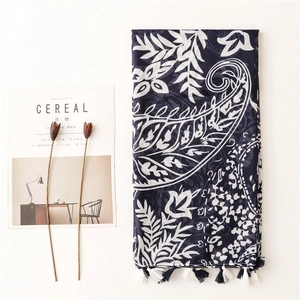 Navy blue paisley scarf with white floral patterns and decorative blue-white fringe tassels