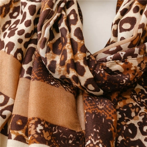 Macro detail of soft leopard print scarf featuring leopard pattern and neutral tones