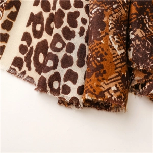 Close-up of leopard and snake print scarves with soft frayed fringe edges and textures
