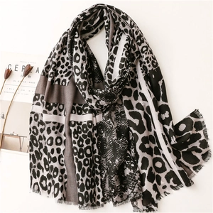 Detailed view of leopard print cotton scarf with fringe edge and geometric patchwork design