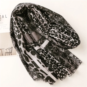 Detailed view of the leopard print cotton scarf featuring mixed animal patterns and fringe