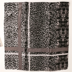 Detail of leopard and snake print scarf featuring soft fringe edges and striped panels