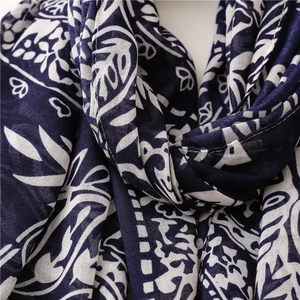 Macro shot of cotton linen scarf showing navy blue paisley patterns and woven texture