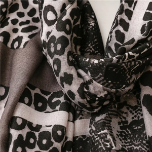 Detail of leopard print cotton linen scarf showing soft fabric texture and fringe edges