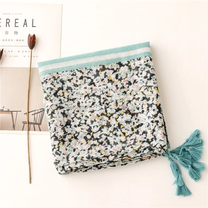 Detail of mint green tassel and abstract floral pattern on lightweight cotton linen scarf