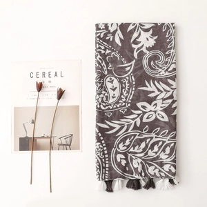 Close-up of brown paisley scarf with elegant tassels on a minimalist background