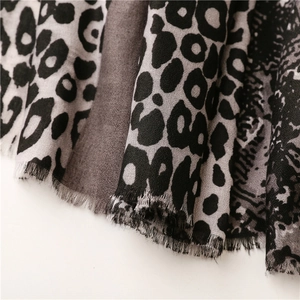 Close-up of leopard print cotton scarf with textured weave and raw fringe edges