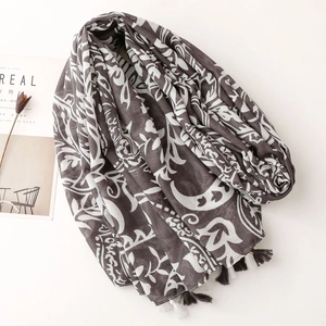 Detail of dark brown linen scarf featuring floral prints and contrast tassel edge decoration