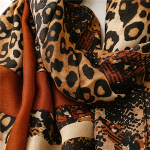 Detailed macro view of leopard print cotton linen scarf with soft brick red color block