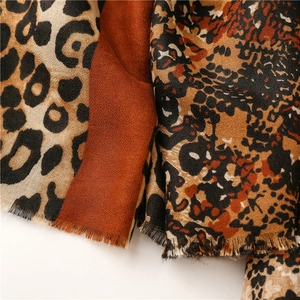 Detail of leopard and snake print scarf with red patch and soft fringed edges
