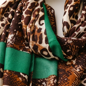 Detailed macro view of leopard print and bright green color block scarf fabric
