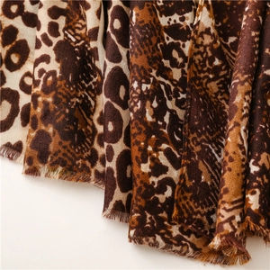 Detailed view of leopard print scarf fabric texture with natural frayed edges