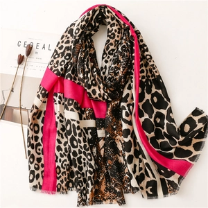 Fashionable leopard print and pink striped scarf with frayed edges on a white background