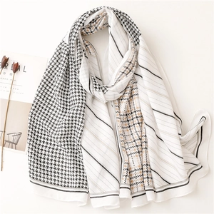 Geruite patchwork sjaal in beige en zwart gepresenteerd met minimalistische props