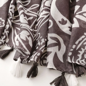 Detailed close-up of bohemian pattern printed scarf with elegant decorative fringe tassels