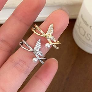 Detail of fishtail rings in gold and silver with sparkling zircons and white pearls