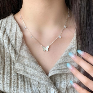 Minimalist silver butterfly necklace with zircon stones worn on a female model
