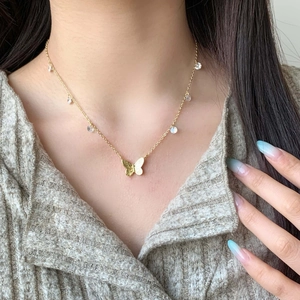 Gold butterfly necklace with zircon drop pendants worn on a female model