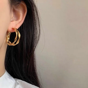 Orecchini a cerchio a spirale a doppio strato placcati in oro indossati da una modella