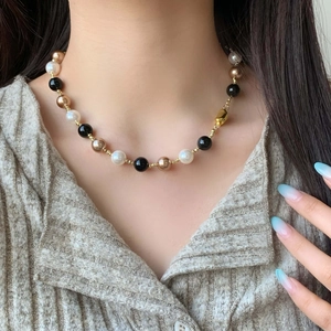 Vintage black onyx and pearl beaded necklace with gold toggle clasp worn by a model