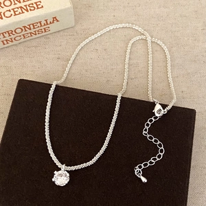 Detail of S925 silver necklace featuring a spiral chain and four-prong zircon pendant