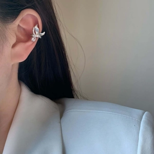 Elegante ear cuff a farfalla in argento con zirconi indossato da una modella in giacca