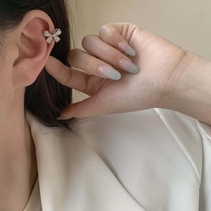 Sparkling zircon bow ear cuff clip earring in silver finish on model ear