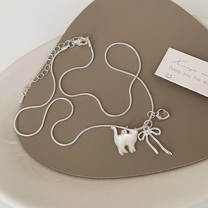 Dettaglio della collana gatto argento con gemma cuore rosa e fiocco su supporto a cuore
