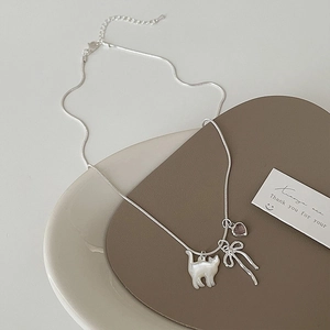 Dettaglio della collana gatto argento con texture conchiglia, fiocco e cuore