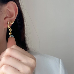 Eleganti orecchini a fiocco placcati in oro con nappa fluida indossati da modella