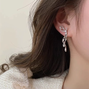 Orecchini a fiocco in argento con eleganti linee metalliche fluide sul modello