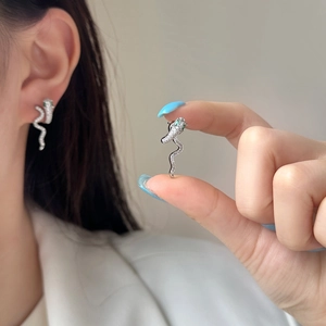 Sparkling snake-shaped silver earrings with white zircon pavé and green gem eyes