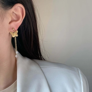 Elegant gold butterfly tassel earrings with sparkling zircon crystals on a model