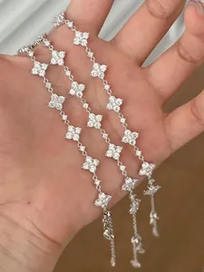 Detailsicht auf silberne Kleeblatt-Armbänder mit funkelndem weißem Zirkonia-Besatz