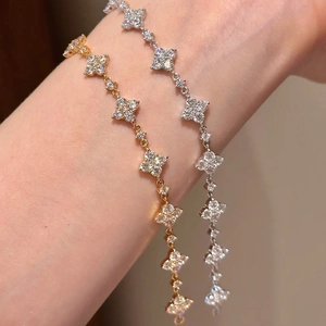 Detailansicht der gold- und silbernen Kleeblatt-Armbänder mit funkelndem Zirkonia-Besatz