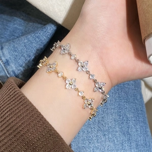 Elegante vierblättrige Kleeblatt-Armbänder in Gold und Silber mit Zirkonia-Steinen am Handgelenk