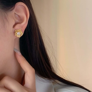 Elegant gold sunflower stud earrings with zircon stone worn by a female model