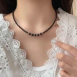 Elegant black crystal beaded necklace with five Shamballa balls on a model's neck