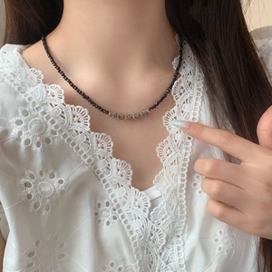 Elegant black crystal bead necklace with gold shambhala balls on a female model