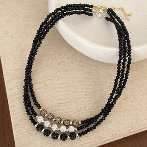 Detailed view of black faceted bead necklaces with sparkling pave rhinestone disco balls