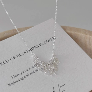 Detail of s925 silver fringe tassel pendant necklace on minimalist display prop