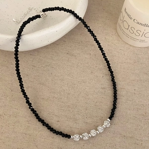 Detail of black crystal beaded necklace with five shimmering silver Shamballa balls